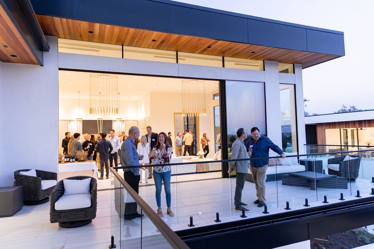 Guests gathering on the terrace of a luxury private home where Astronomic hosts an investor dinner.